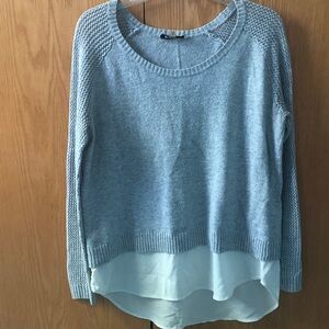 Knit sweater with flowy fabric bottom.
